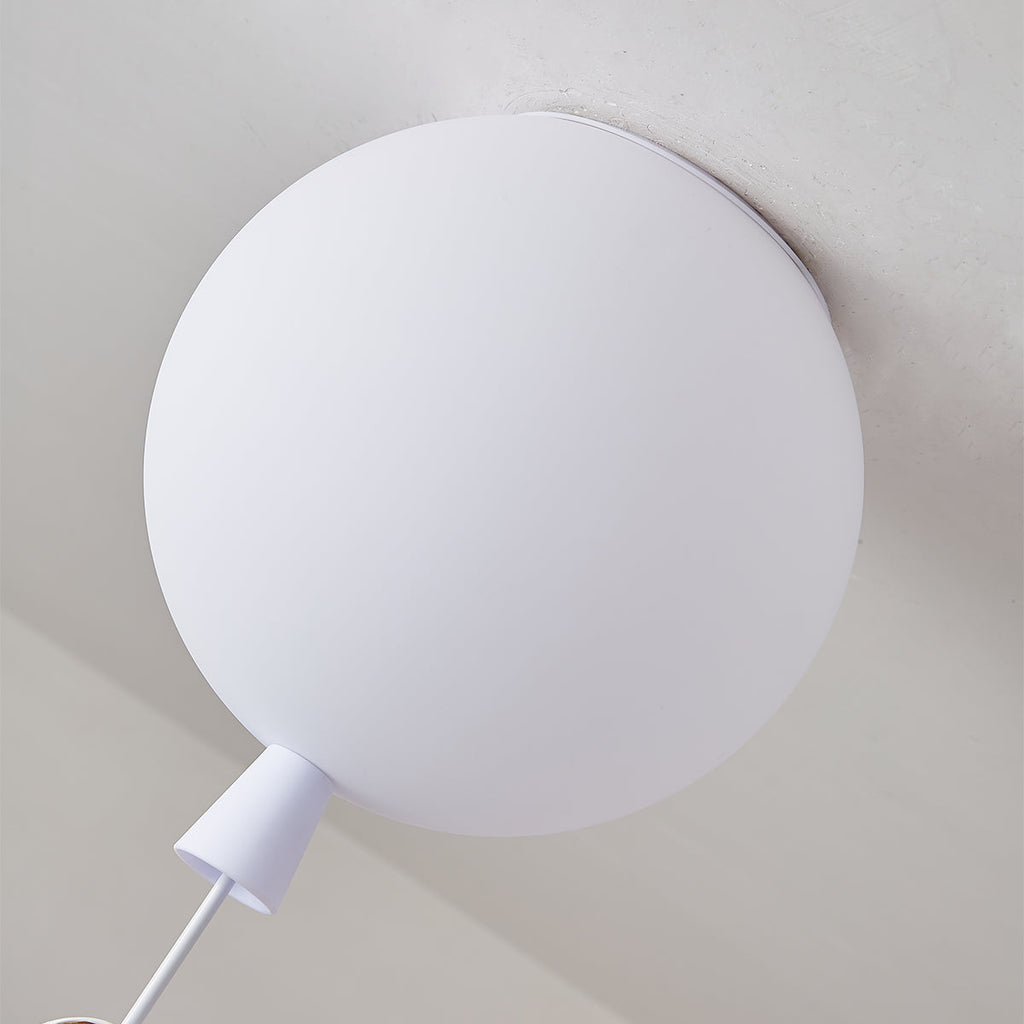 Close view of the frosted white balloon diffuser, the ceiling mount and the cap of this Clérachic ceiling light.