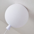 Close view of the frosted white balloon diffuser, the ceiling mount and the cap of this Clérachic ceiling light.