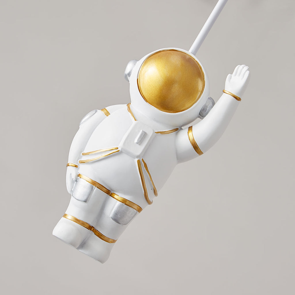 Close view of the white astronaut figure with a gold visor and gold trim on this Clérachic balloon ceiling light.