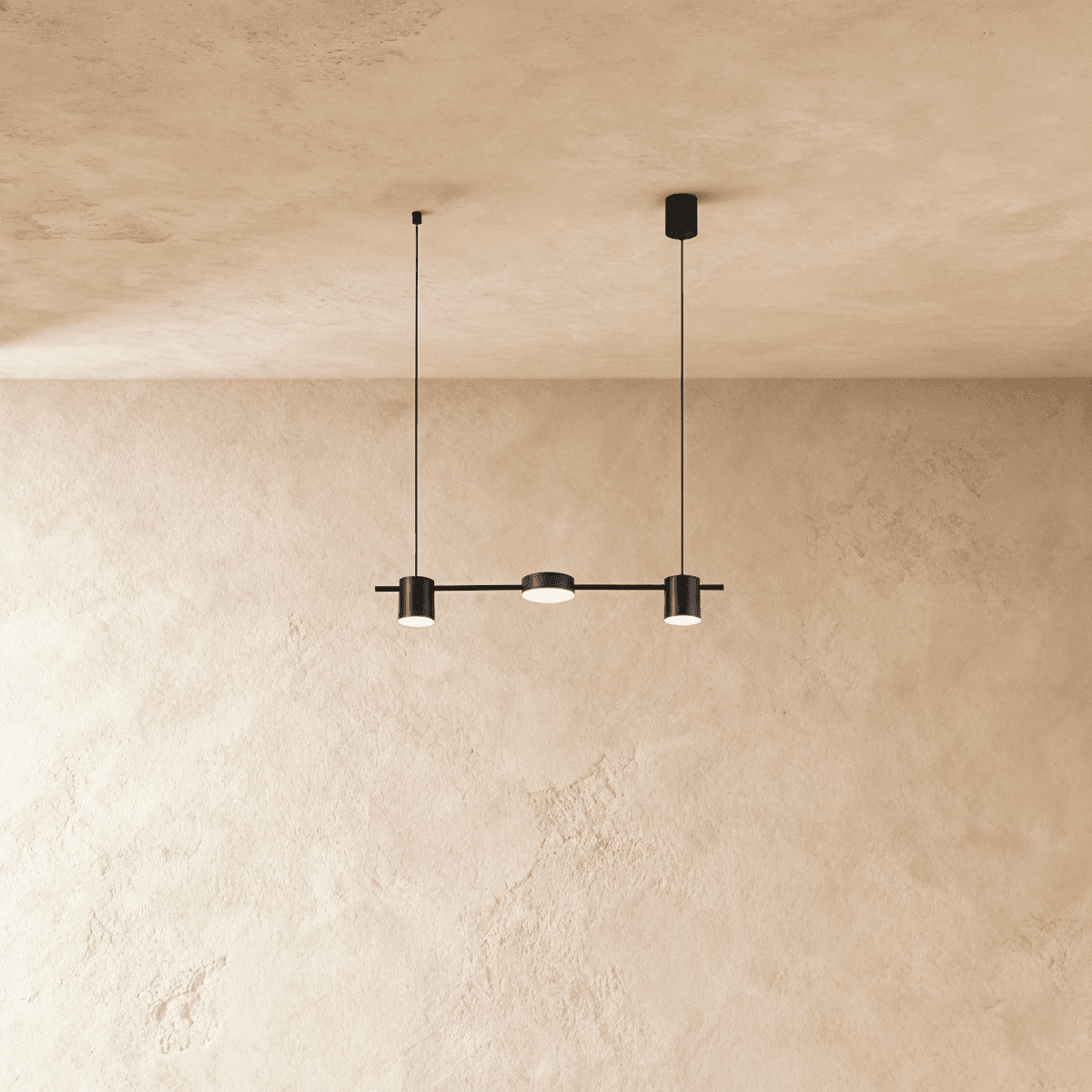 Another angle of the Clérachic black three-head pendant bar, cylindrical heads glowing warm white on thin support cables.