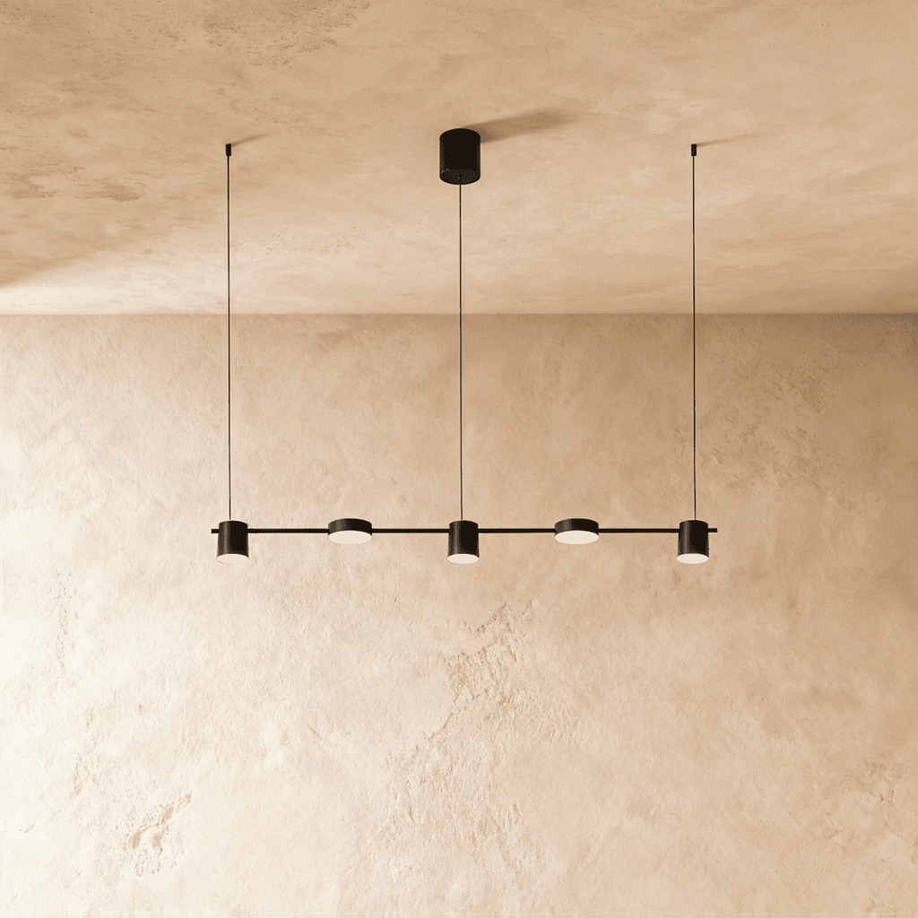 The Clérachic black five-head linear pendant bar, its round LED heads glowing warm white in a row beneath the ceiling.