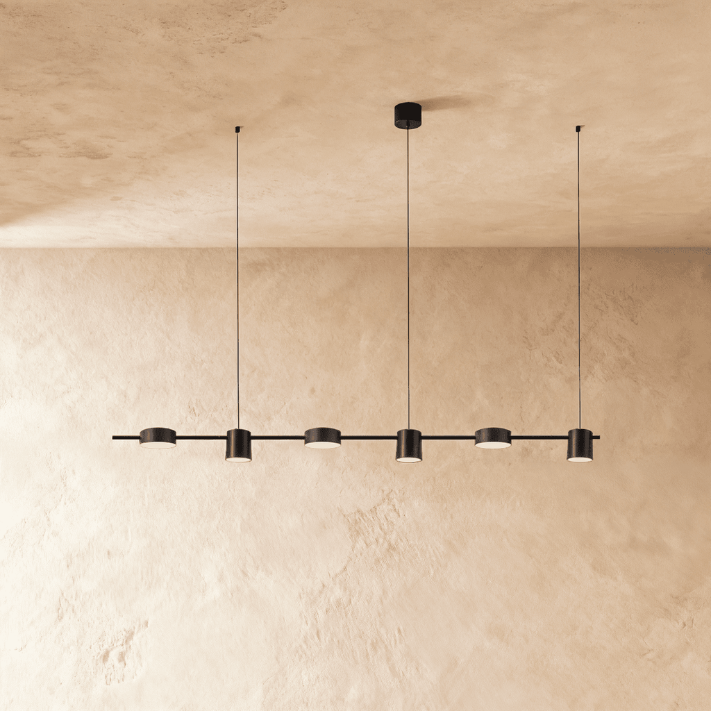 The Clérachic black six-head linear pendant bar, its round LED heads glowing warm white in a long row overhead.