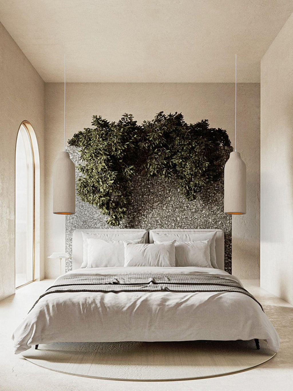 Two slender beige Clérachic pendant lights hanging beside a bed in a tall room with an arched window and a leafy headboard.