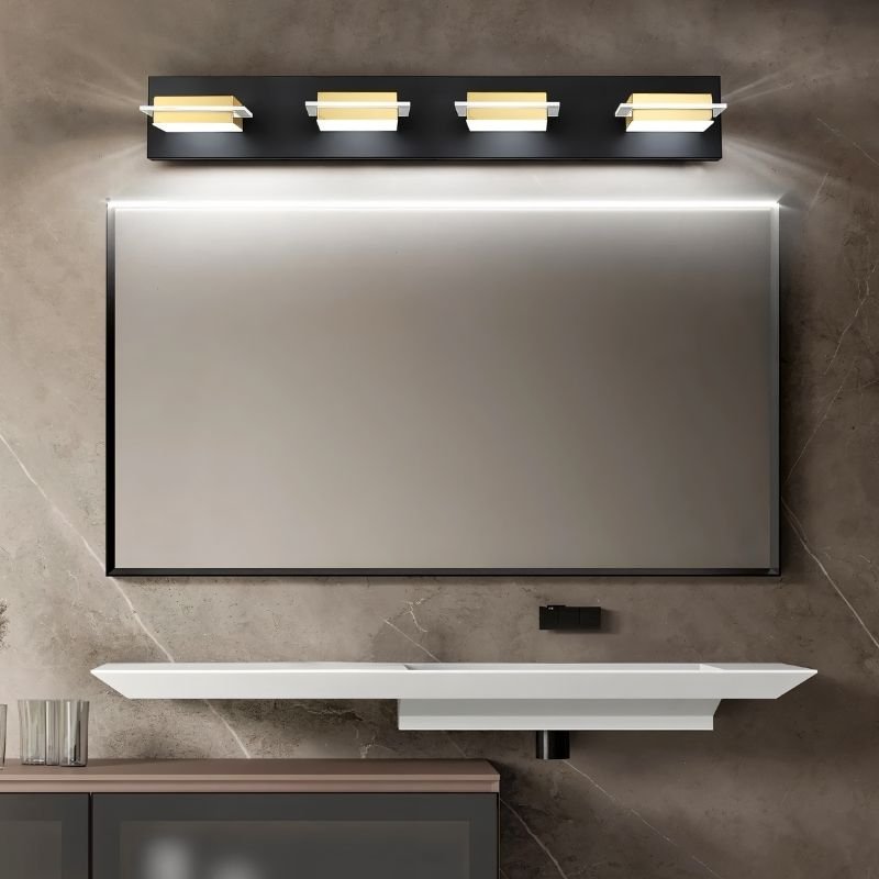 Clérachic four-head black wall bar with gold-toned bands and frosted diffusers, centred above a black-framed bathroom vanity mirror.