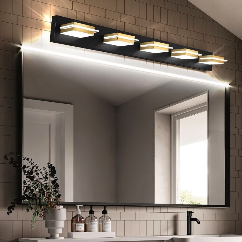 Clérachic five-head black wall bar with gold bands and frosted diffusers, lit above a black-framed mirror and a small vanity shelf.