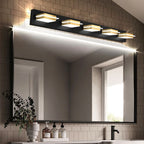 Clérachic five-head black wall bar with gold bands and frosted diffusers, lit above a black-framed mirror and a small vanity shelf.
