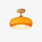 Studio shot of the Clérachic Bauhaus glass disc ceiling light in orange glass, shown against a plain white background.