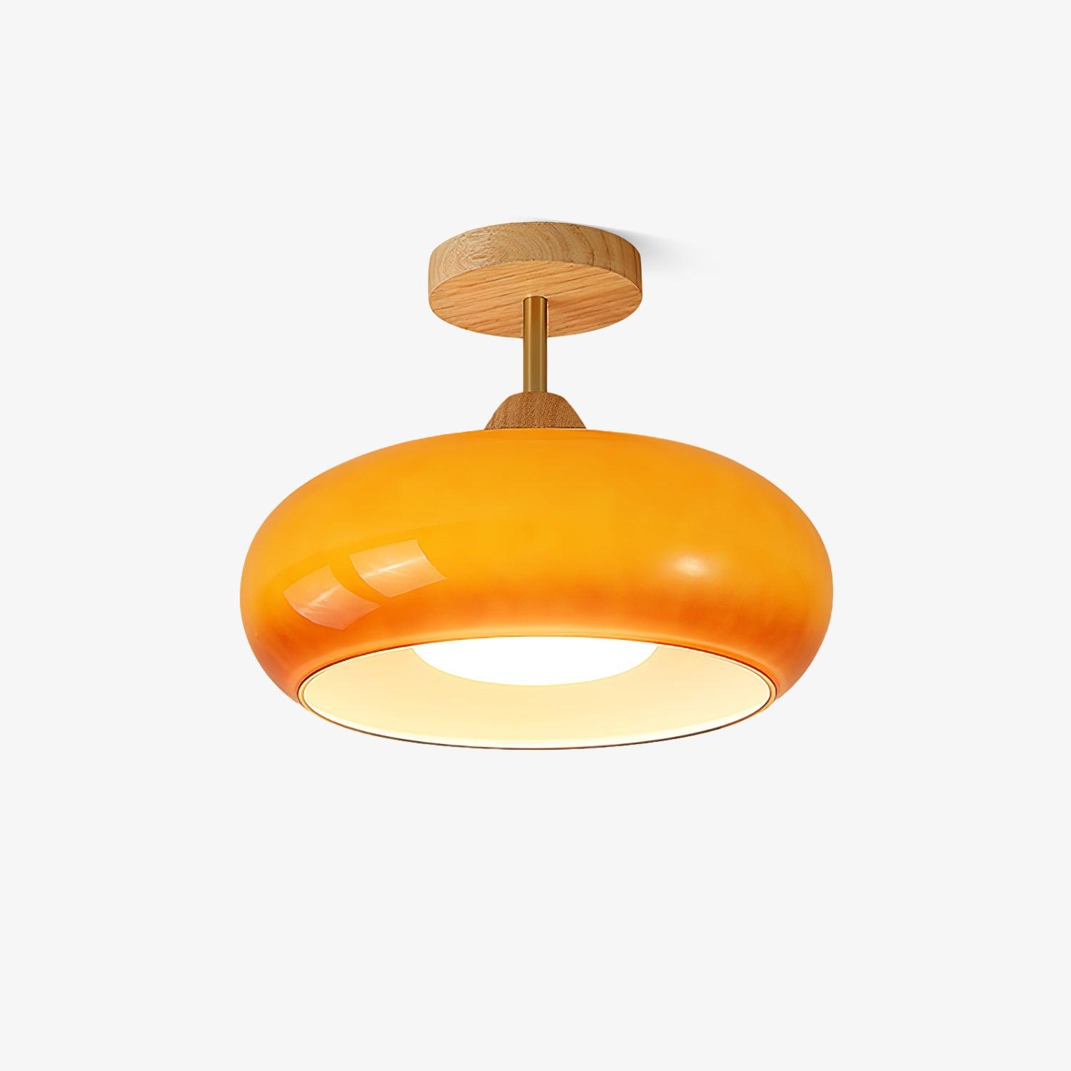 Studio shot of the Clérachic Bauhaus glass disc ceiling light in orange glass, shown against a plain white background.