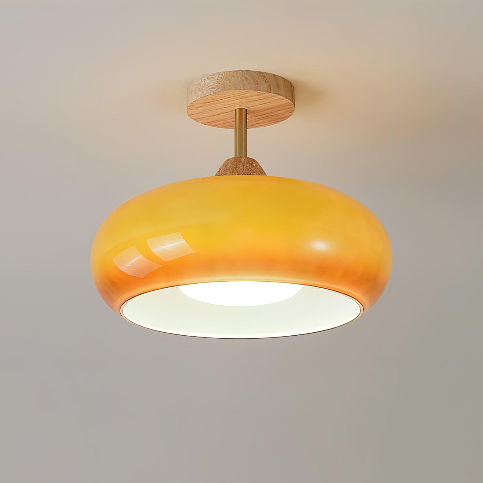 Clérachic Bauhaus glass disc ceiling light seen from below, the amber glass ring framing its bright recessed diffuser.