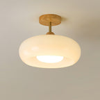 Low-angle view of the Clérachic Bauhaus glass disc ceiling light in cream glass, its opal diffuser lighting downward.
