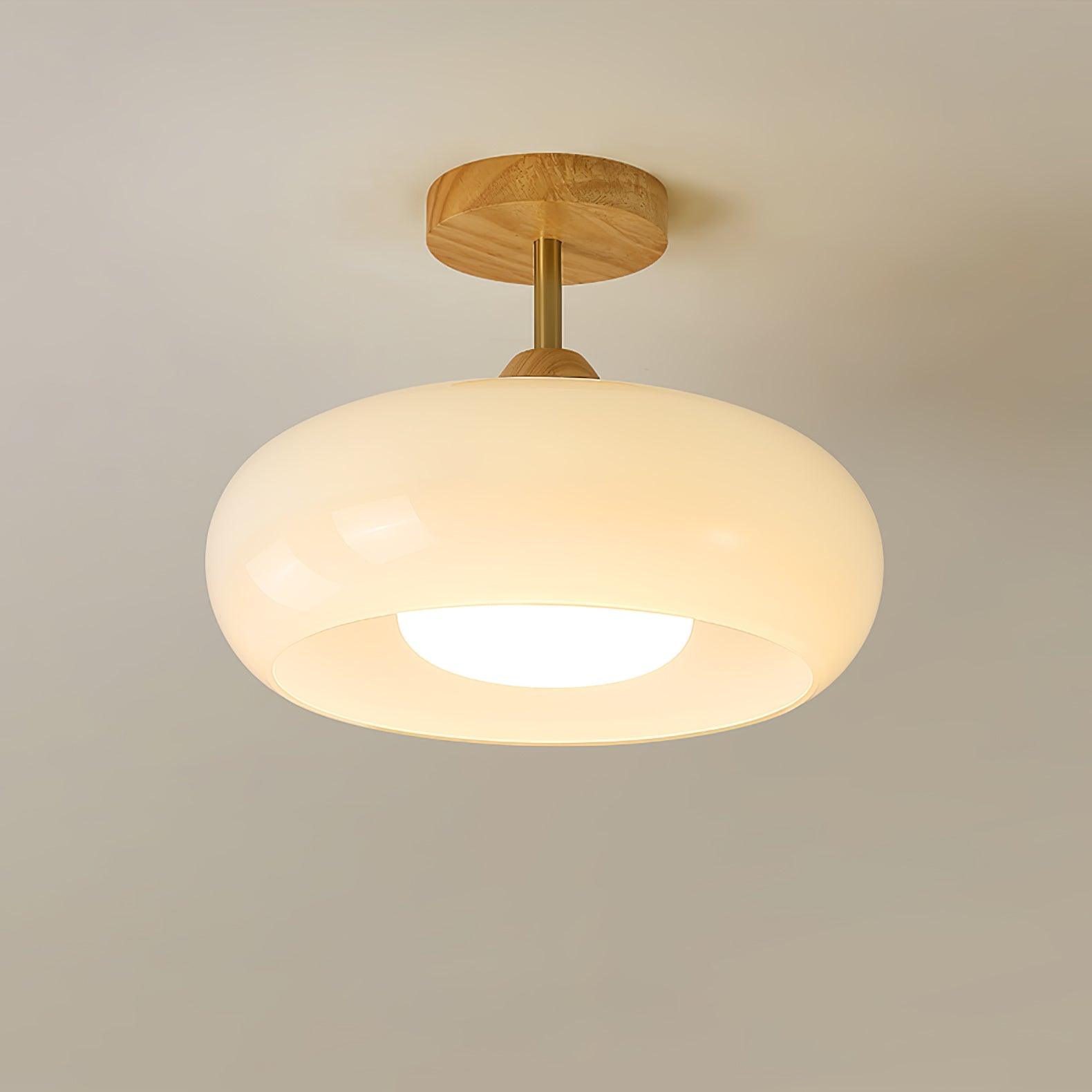 Low-angle view of the Clérachic Bauhaus glass disc ceiling light in cream glass, its opal diffuser lighting downward.
