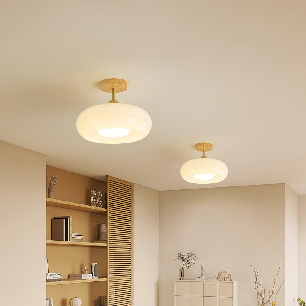 Two Clérachic Bauhaus glass disc ceiling lights in white, mounted a short way apart across a living room ceiling.