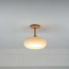 Clérachic Bauhaus glass disc ceiling light in cream opal, lit on a white ceiling above a moulded plaster cornice.