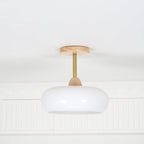 Clérachic Bauhaus glass disc ceiling light unlit and seen head-on, the glass reading a soft matt white in daylight.