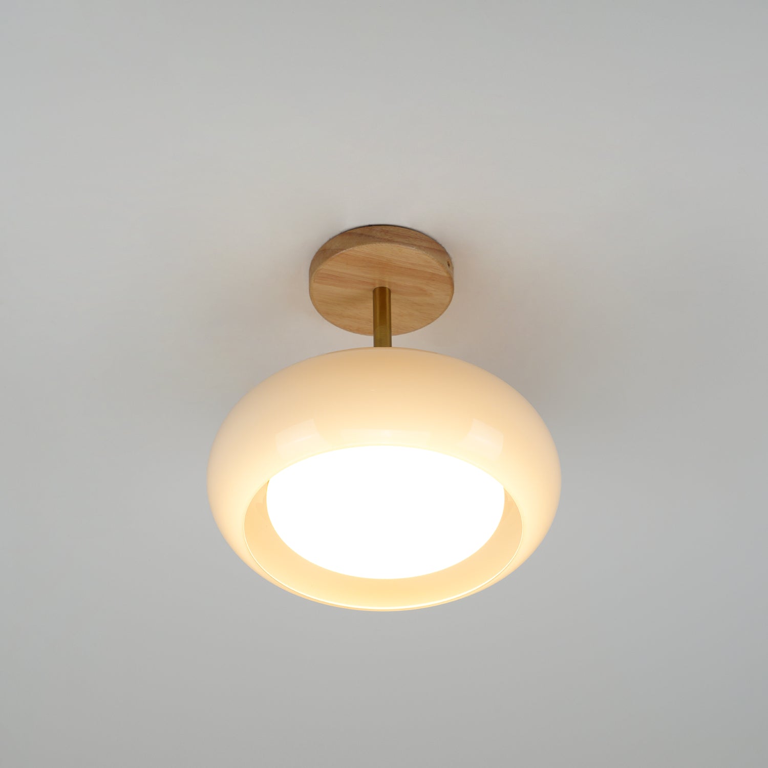 Clérachic Bauhaus glass disc ceiling light photographed straight on, the recessed opal diffuser glowing at its centre.