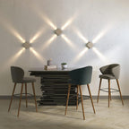Clérachic three square wall lamps in a light finish, beams crossing the wall above a dining table and bar stools.
