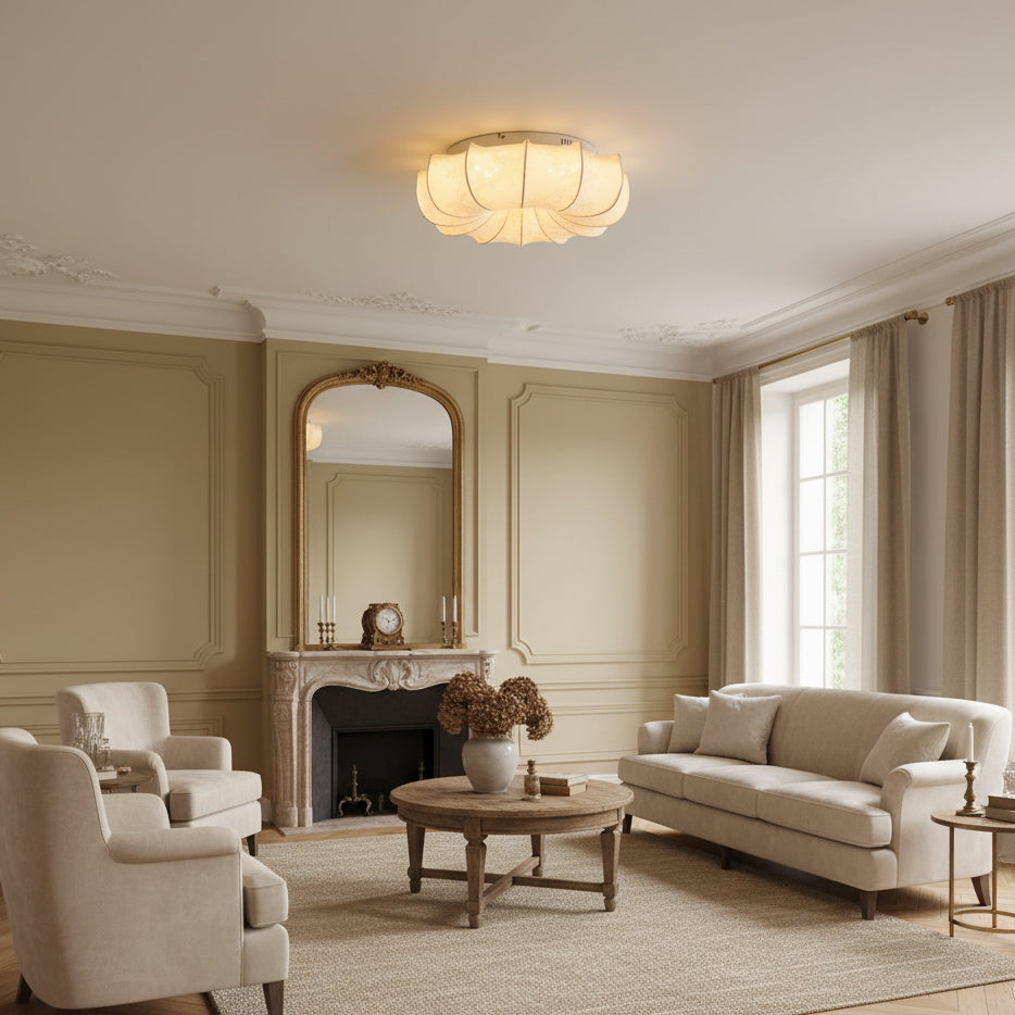 This Clérachic fabric ceiling light glows in a panelled living room with a marble fireplace, a cream sofa and armchairs.