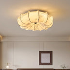 Close view from below of this Clérachic petal-shaped ceiling light, lit warm, with a floral print on the fabric panels.
