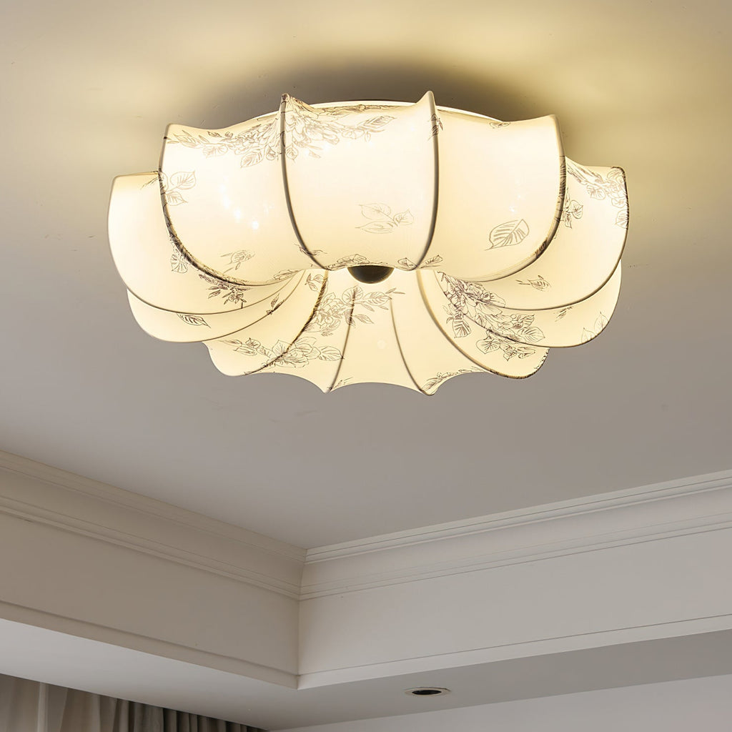 Close view of the lit fabric petals of this Clérachic ceiling light, with fine floral print and a dark centre knob.