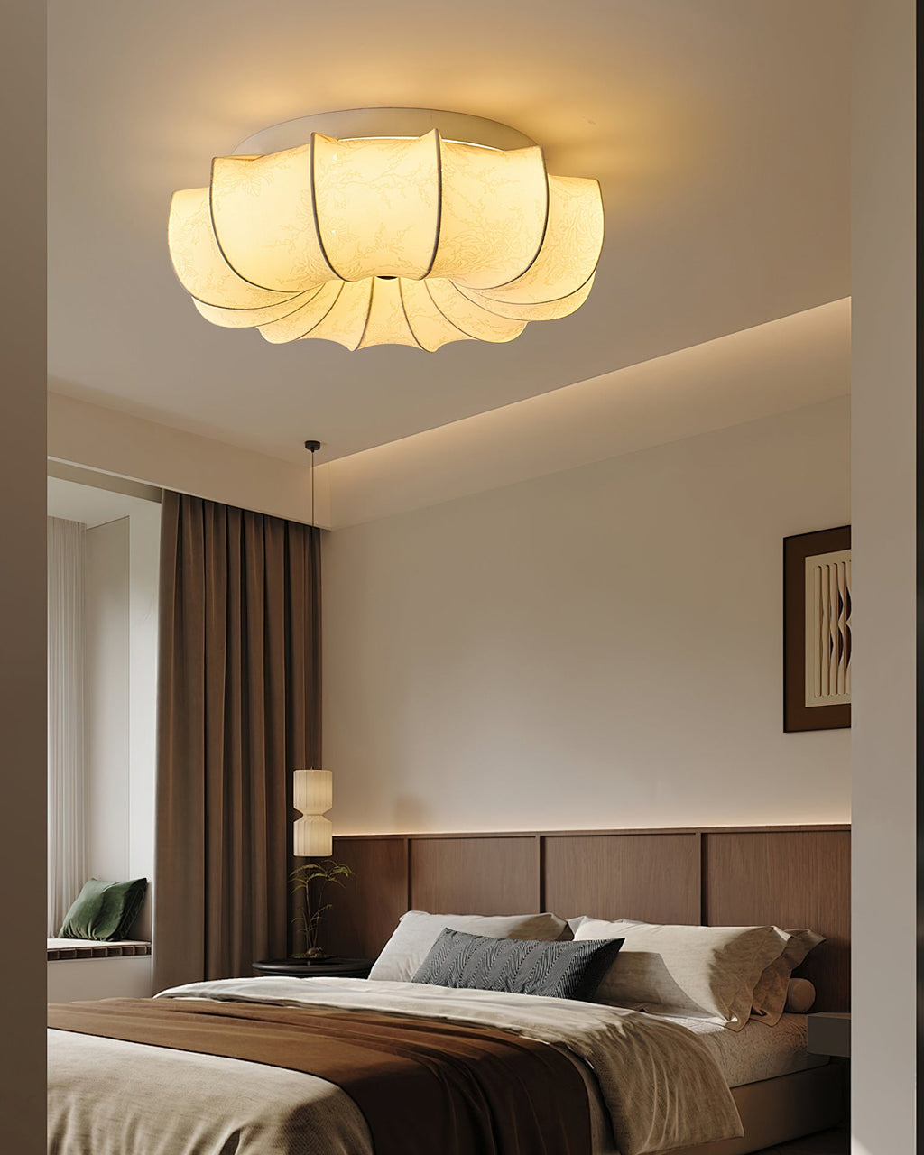 Clérachic fabric ceiling light lit above a bed with brown and grey bedding, a wood-panelled headboard wall and a framed print.