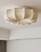 Close view from below of this unlit Clérachic ceiling light, with a pale floral pattern on its fabric petals.