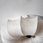 Close view of the folded fabric petals and dark wooden knob on this Clérachic ceiling light, with a faint branch print.