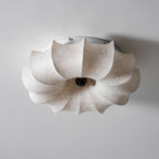 View from below of this Clérachic ceiling light, unlit, with its folded fabric petals and dark centre knob.
