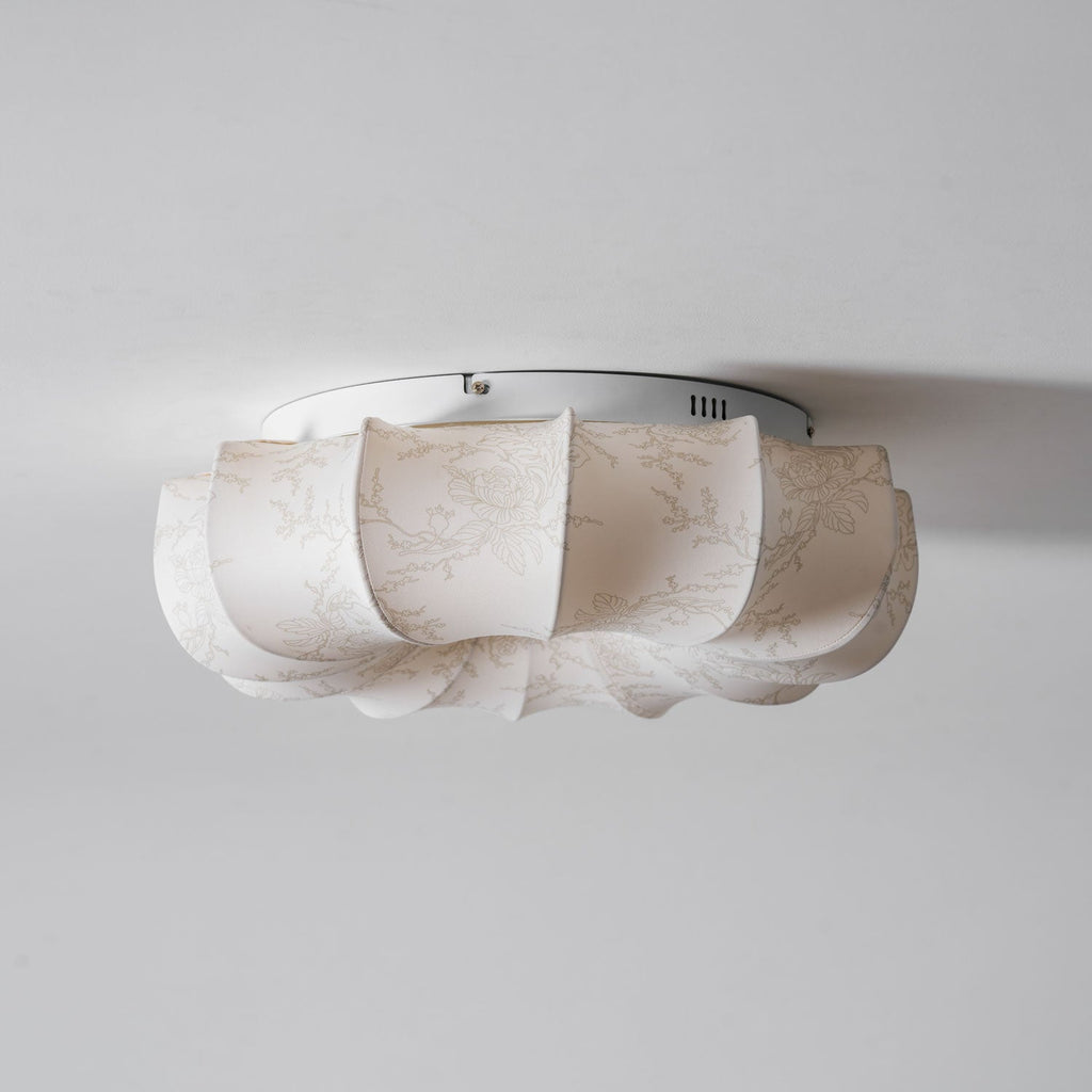 Side view of the white base plate and fabric petals on this Clérachic ceiling light, seen close to the ceiling.