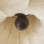 Close view of the dark wooden knob and fine branch print on this Clérachic ceiling light.