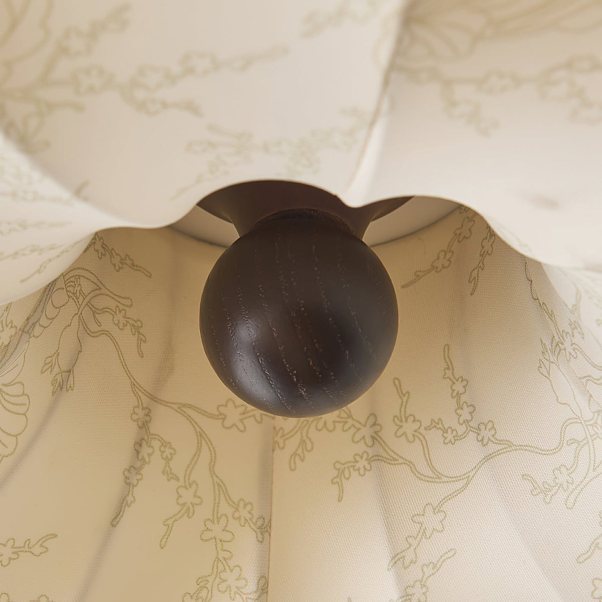 Close view of the dark wooden knob and fine branch print on this Clérachic ceiling light.