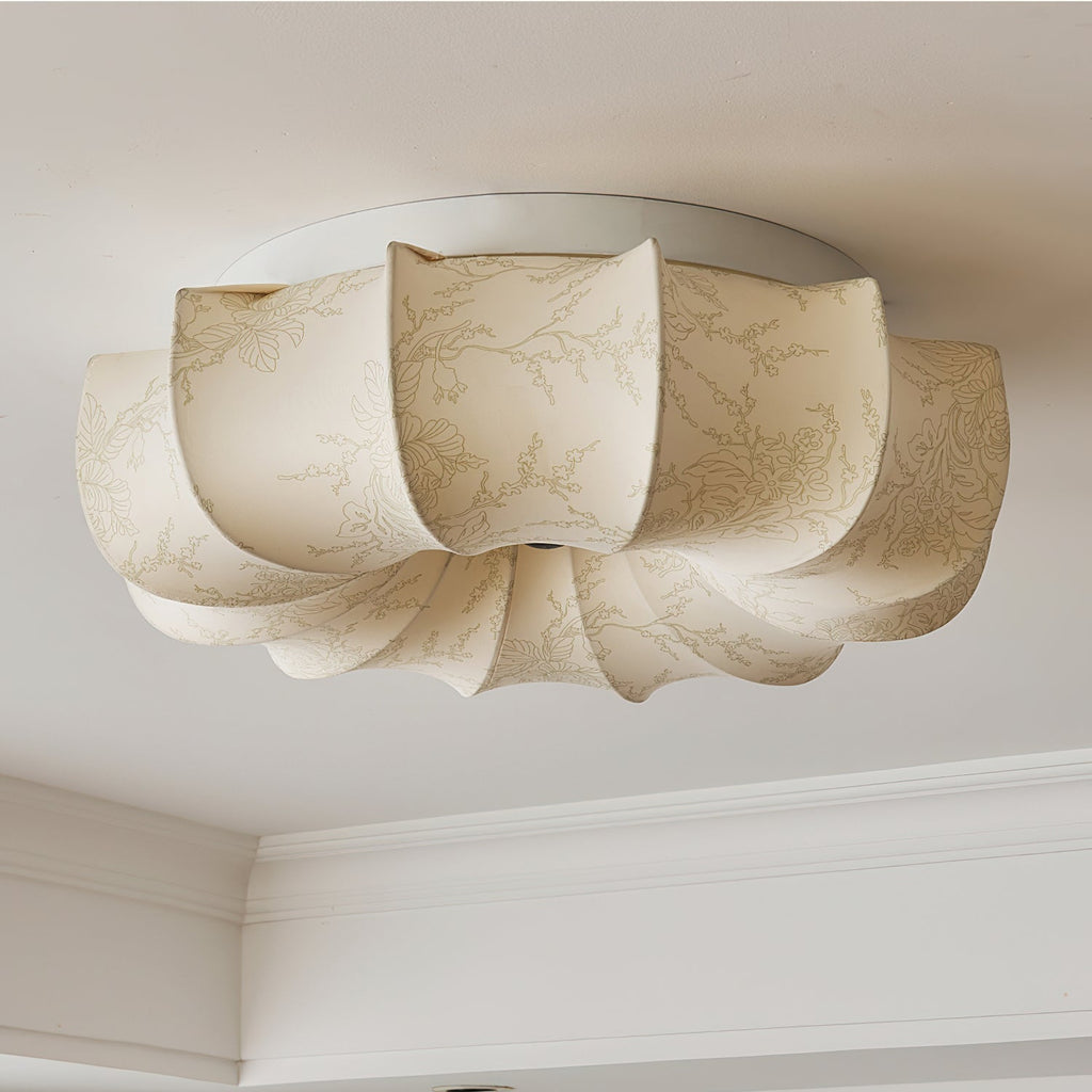 A Clérachic fabric ceiling light seen from below, unlit, with a coved ceiling edge in the corner of the frame.