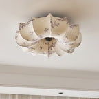 A Clérachic fabric ceiling light with a grey floral print on beige petals, unlit, seen above a coved ceiling edge.