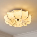 Warm-lit Clérachic fabric ceiling light with a floral print, seen from below with a pale ceiling edge at the corner.