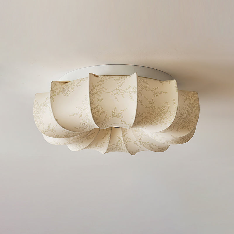 A Clérachic ceiling light, unlit, in plain cream fabric with a faint pattern and a white base plate.