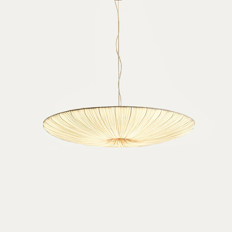 A wider, flatter Clérachic pendant with a beige fabric shade and gathered folds, hanging from a thin cord on a light backdrop.