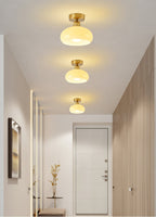 Three Clérachic ceiling lights in a row down a narrow hallway with wood-panelled walls and a door at the end.