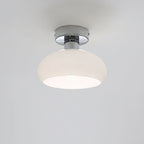White glass dome with a chrome canopy and a bright inner rim, a Clérachic ceiling light on a pale grey backdrop.
