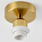 Close view of the brushed brass canopy and white bulb holder of this Clérachic ceiling light, shown without the glass shade.