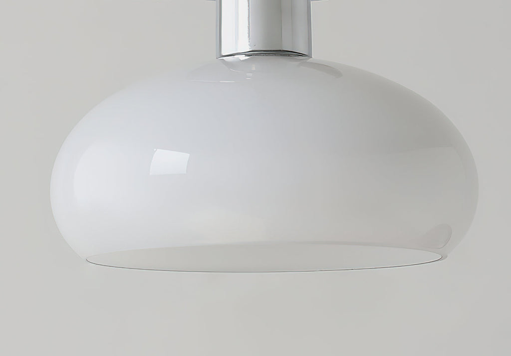 Side view of the smooth white glass dome and chrome stem of this Clérachic ceiling light on a grey backdrop.