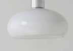 Side view of the smooth white glass dome and chrome stem of this Clérachic ceiling light on a grey backdrop.
