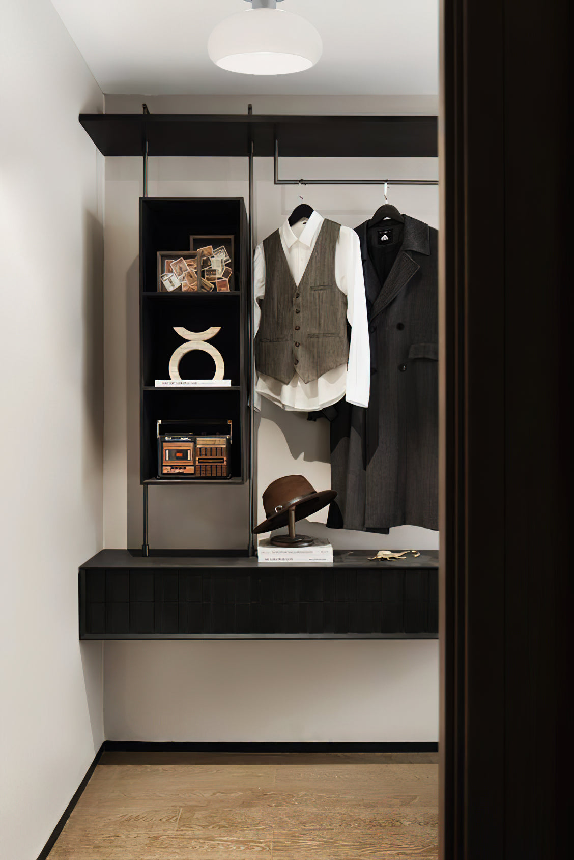 A Clérachic ceiling light with a white glass dome above a walk-in wardrobe with dark shelving and hanging coats.