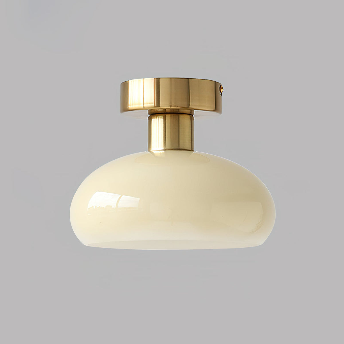 Cream-beige glass dome with a polished brass canopy and stem, a Clérachic ceiling light on a mid-grey backdrop.