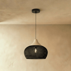 Clérachic black woven rattan pendant light with a rounded dome shade and beige wood cap suspended from the ceiling.
