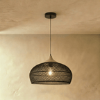 Clérachic black rattan dome pendant light with an open weave shade and beige wood cap hanging from a black cord.