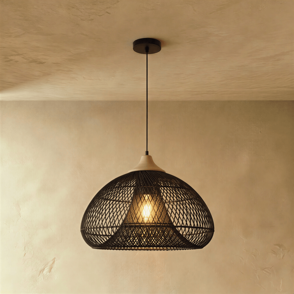 Clérachic black rattan pendant light with a woven dome shade and beige wood cap suspended over a plaster interior.