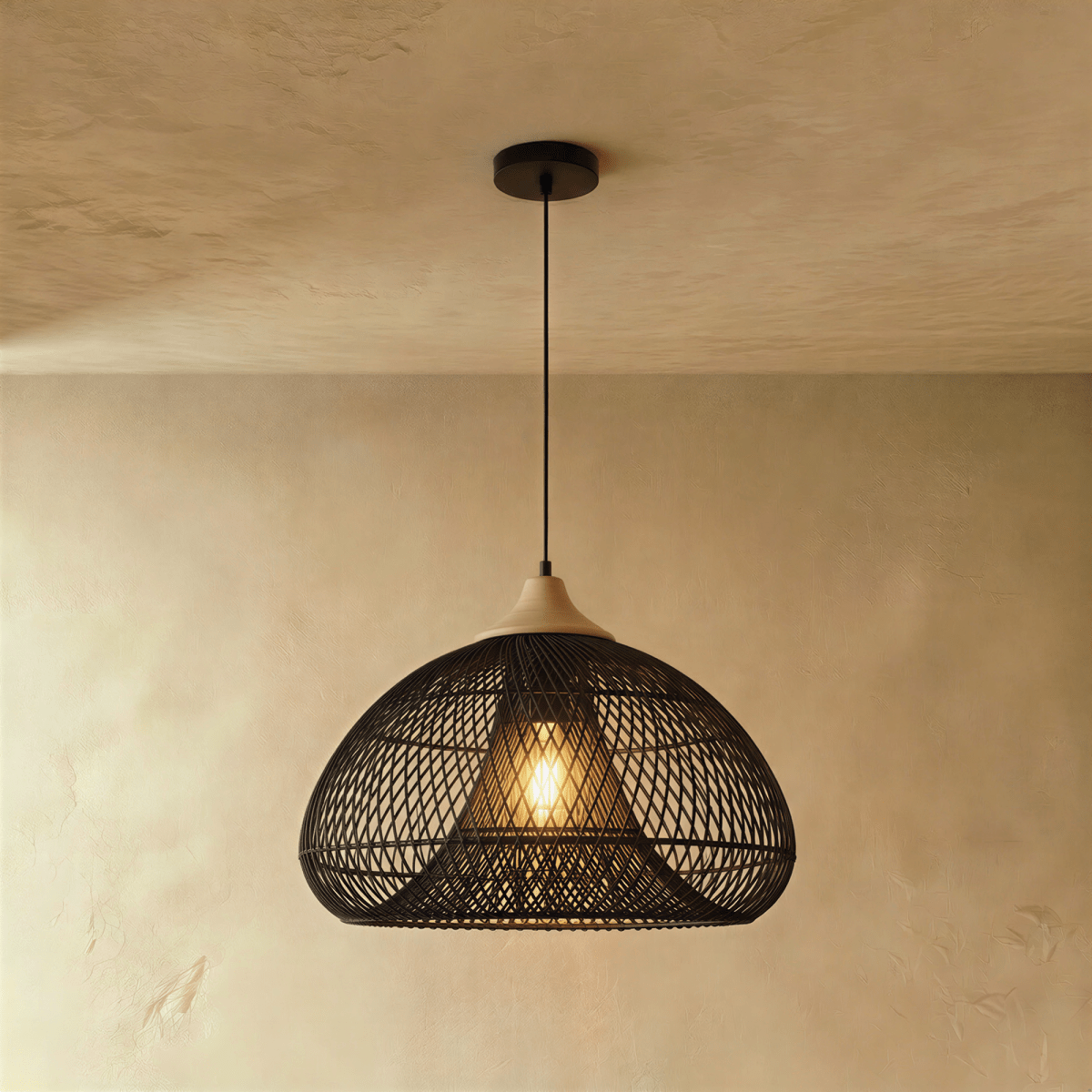 Clérachic black rattan pendant light with a woven dome shade and beige wood cap suspended over a plaster interior.