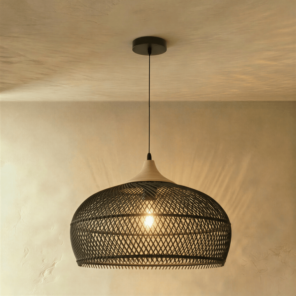 Clérachic black woven rattan pendant light with a rounded dome shade and beige wood cap against a warm plaster wall.
