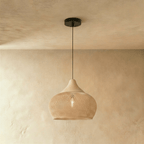 Clérachic natural rattan pendant light with a woven beige dome shade and matching wood cap over a plaster wall.