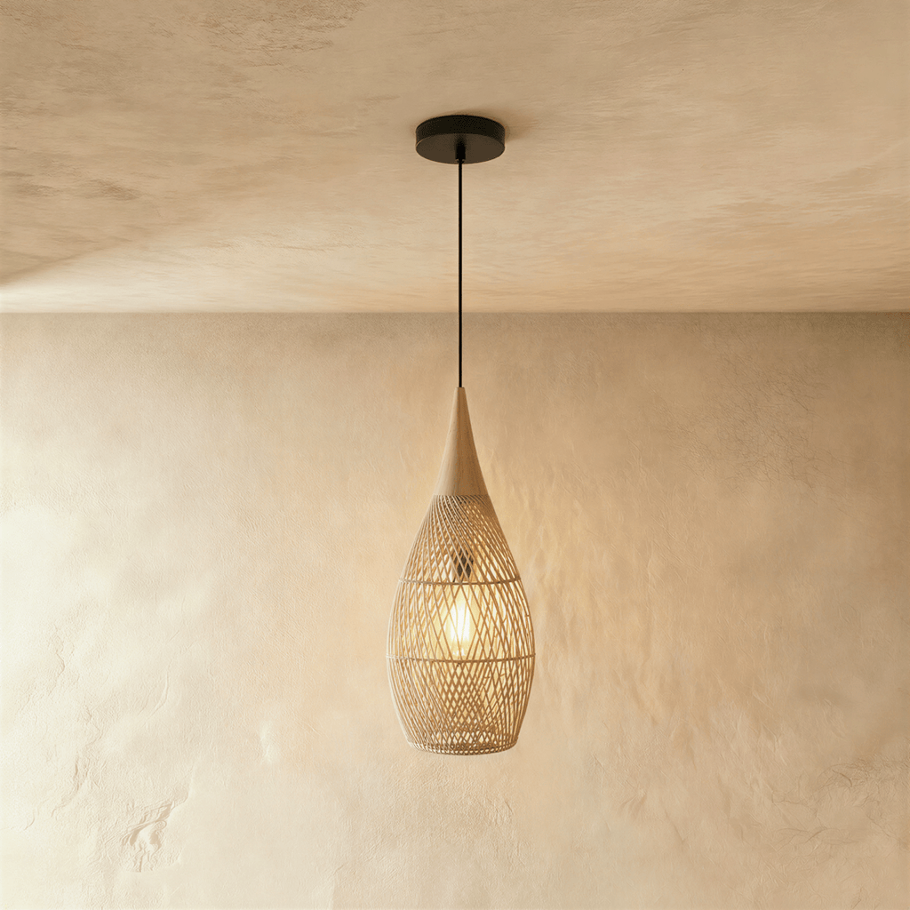 Clérachic natural rattan pendant light with a beige teardrop cage shade and wood cap hanging against plaster.