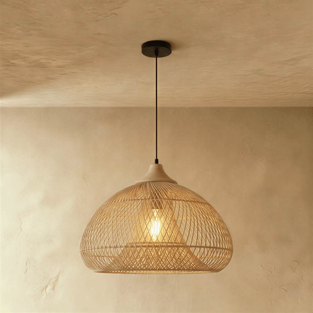 Clérachic natural rattan pendant light with a woven beige dome shade and wood cap, lit against a plaster wall.